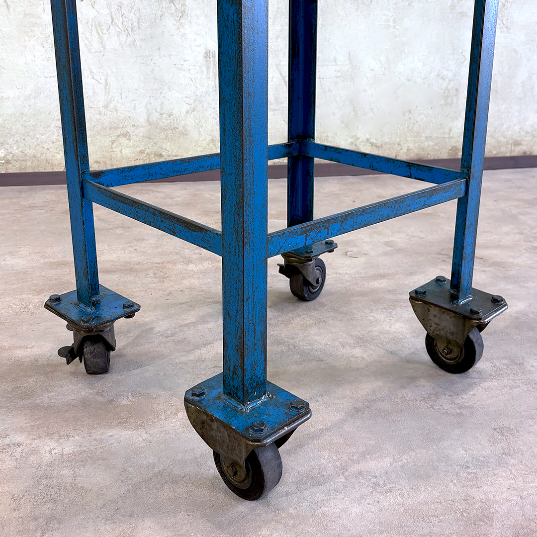 Carrito industrial azul, detalle de ruedas y estructura metálica