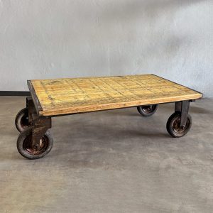 Mesa industrial de hierro y madera con ruedas y estructura originales