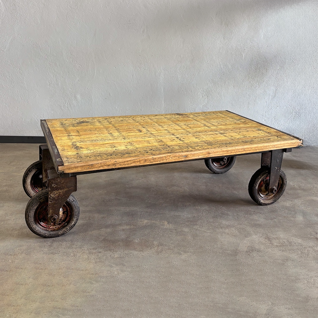 Mesa industrial de hierro y madera con ruedas y estructura originales