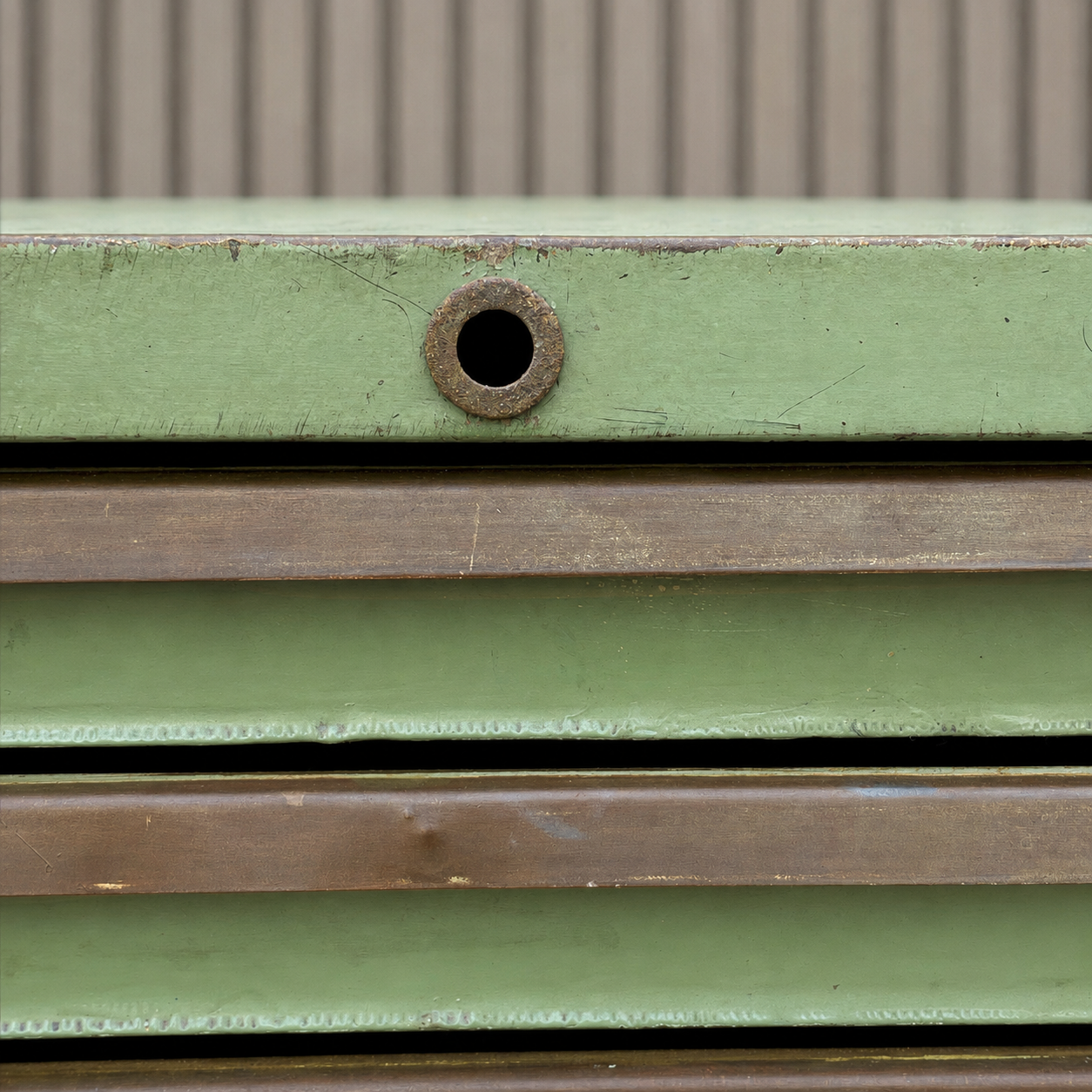 Detalle de estructura metálica verde con marcas de uso y pátina original
