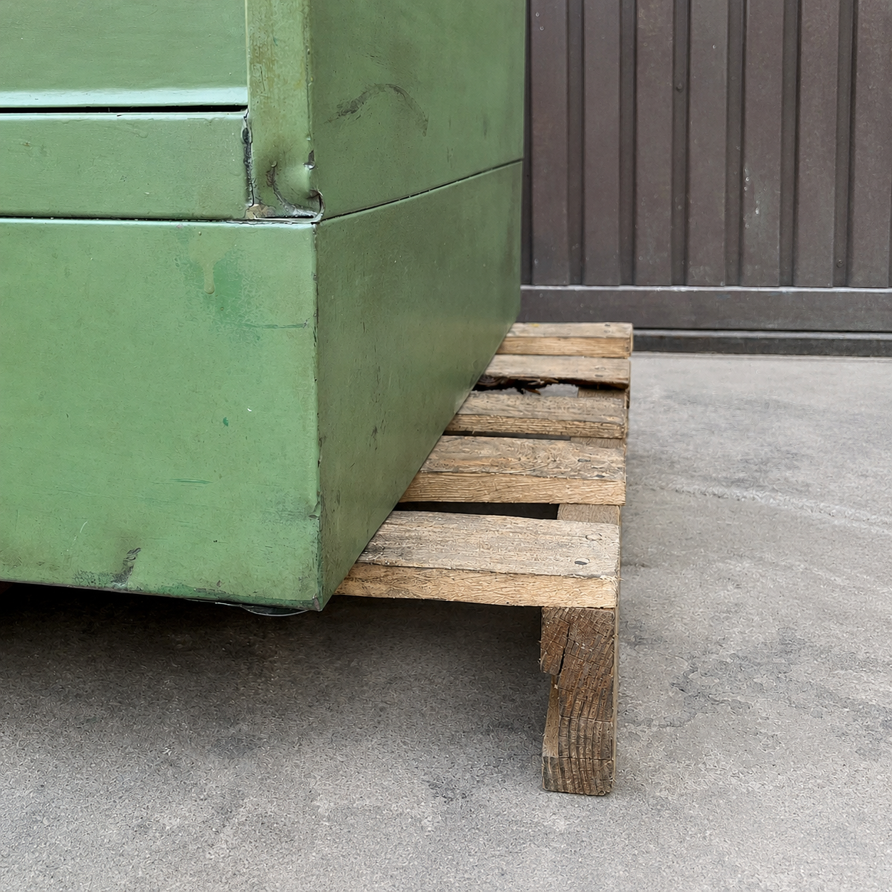 Detalle lateral de cajonera metálica verde con marcas de uso