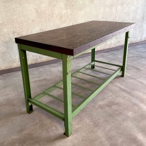 Mesa de trabajo industrial verde con tablero de madera y balda inferior metálica