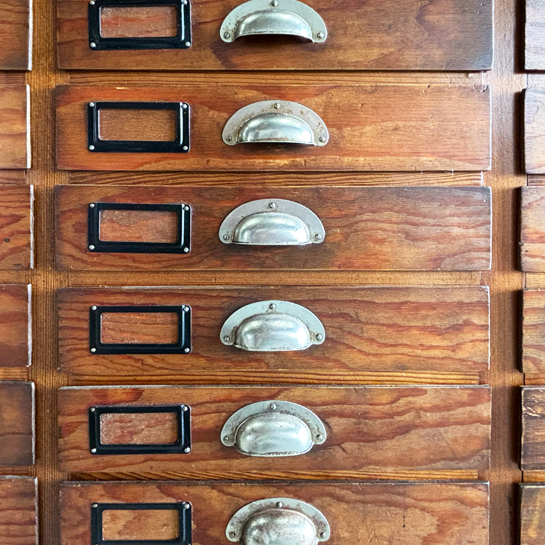 Detalle de cajones de madera con tiradores metálicos y portaetiquetas