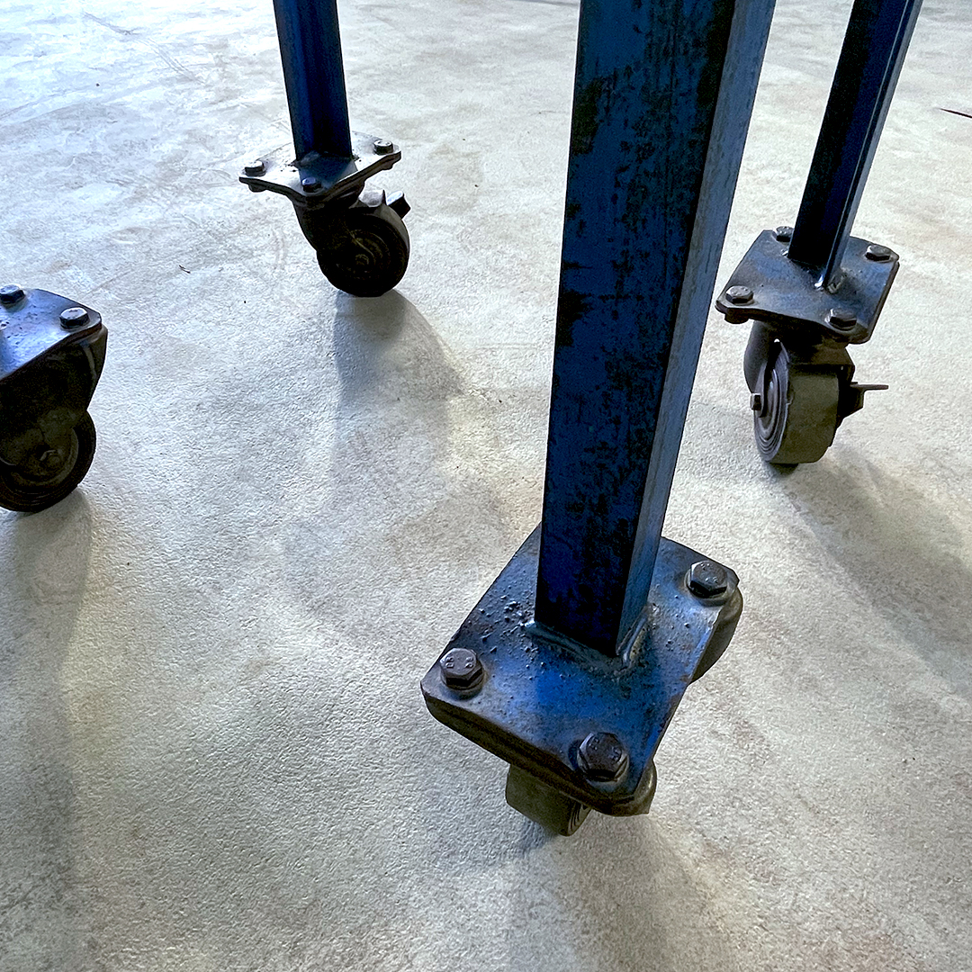 Detalle de las ruedas originales del carrito industrial azul con dos baldas