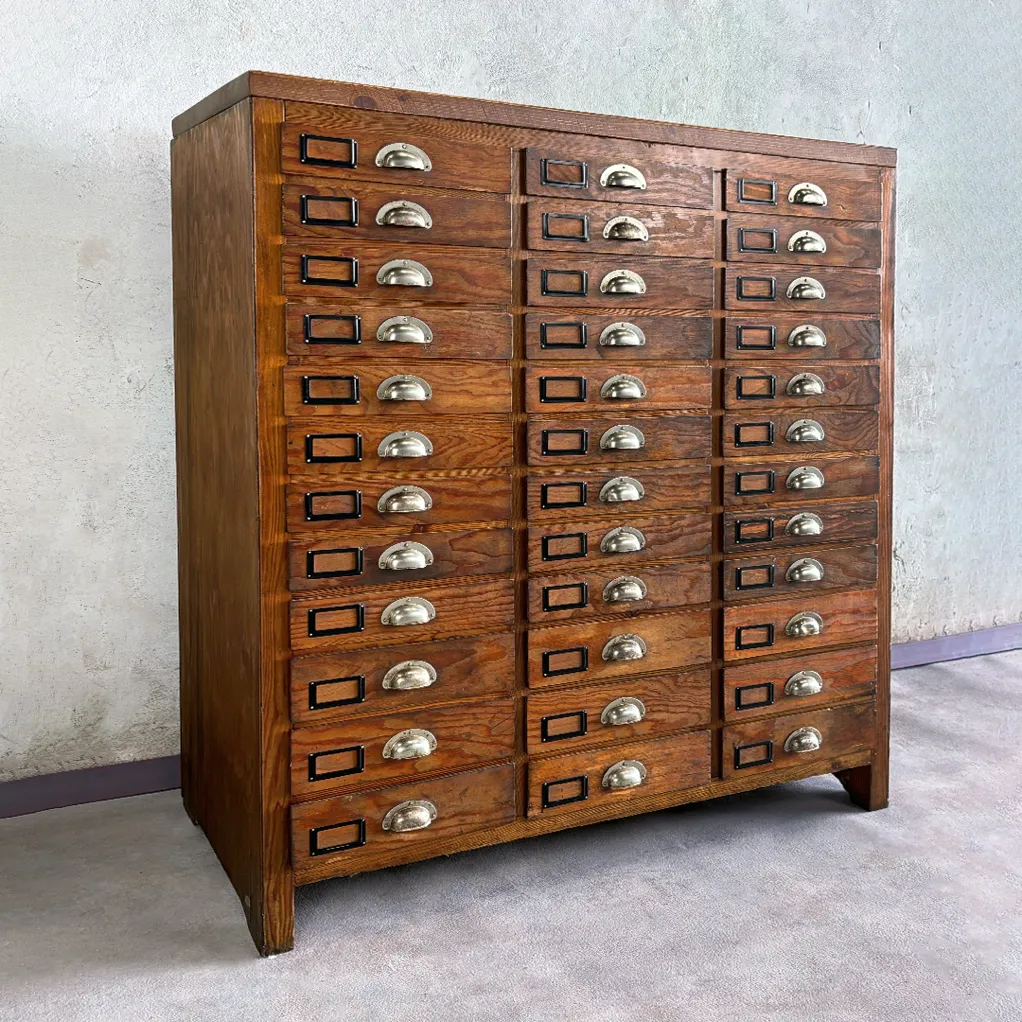 Cajonera industrial vintage de madera como almacenaje en salón contemporáneo.