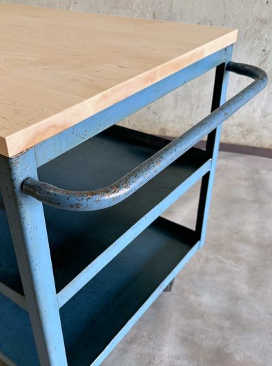Carrito industrial azul con tablero de madera en sesión de fotos