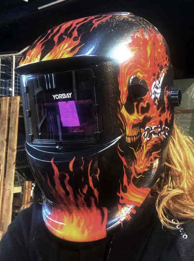Mujer con casco de soldar muy bold en el taller