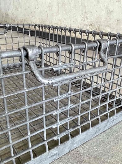 Detalle de cesta de rejilla metálica con asa de hierro